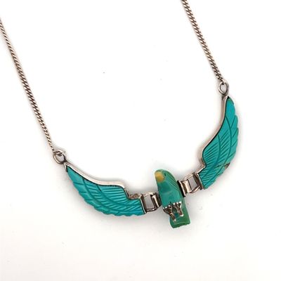 collier avec des ailes en turquoise et une perle verte, monté sur une chaîne en argent