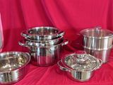 several stainless steel pots and pans on a red cloth