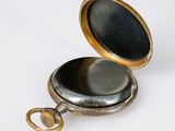 pocket watch on a white background with a key in the case