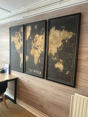 three framed maps on the wall of a home office