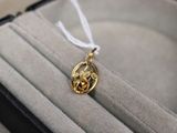un collier en or orné d'un oiseau, présenté dans un coffret