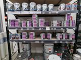 de nombreux seaux de peinture sur les étagères de la pièce