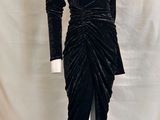 une photo d'une robe noire posée sur un socle de mannequin