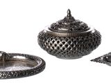 a silver candle holder and a silver ashtray on a white background