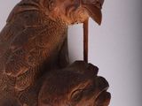 a wooden sculpture of a cat and a bird hanging on a wall