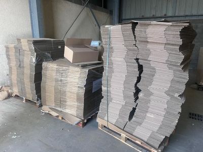 plusieurs piles de cartons empilées les unes sur les autres dans un entrepôt