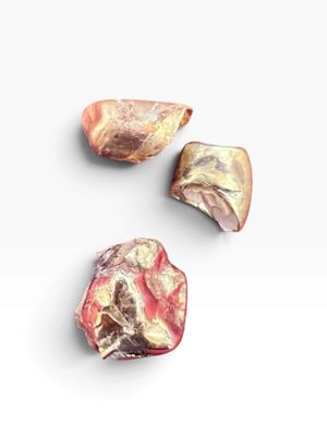 On voit trois morceaux de viande crue posés sur une surface blanche