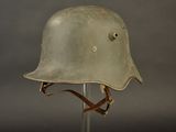 an old helmet on a stand against a gray background
