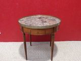 a small table with a marble top sitting on top of a carpeted floor