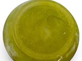 a close up of a green glass object on a white surface