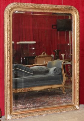 un grand miroir dans lequel se reflète un canapé dans une pièce
