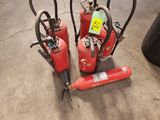 several fire extinguisors are lined up on the floor in a warehouse