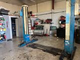 un garage avec deux ponts élévateurs bleus à l'intérieur