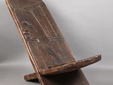 une vieille chaise en bois posée sur une surface blanche