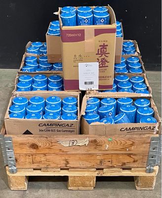 plusieurs cartons de canettes de soda bleu posés sur une palette en bois