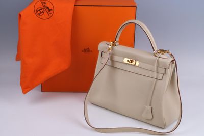 an orange and white box with a grey bag and a orange scarf
