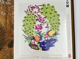 an open book with a picture of a peacock and flowers on it