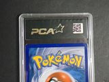 the pokemon card is in a plastic case on a table