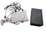 a video game console and a game controller next to a box