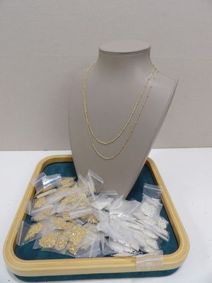 a display of gold and silver jewelry on a tray