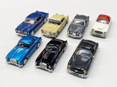 plusieurs petites voitures sont alignées sur une surface blanche