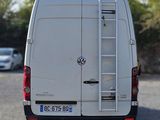 a white van parked in a parking lot with a ladder on the back