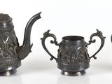 trois objets en pewter posés les uns à côté des autres sur une surface blanche