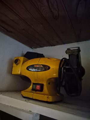une ponceuse sans fil jaune posée sur une étagère dans une pièce