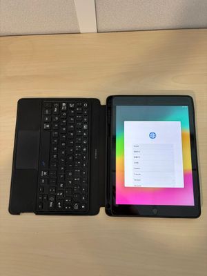 une tablette avec un clavier posée à côté d'un ordinateur portable sur une table