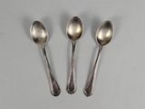 three silver spoons sitting next to each other on top of a table