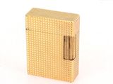 l'image d'un briquet doré posé sur une surface blanche