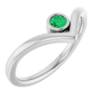 une bague en or blanc sertie d'une émeraude au centre