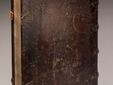 an old book sitting on top of a table next to a white wall