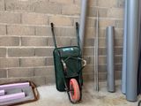 a wheelbarrow and a cart in front of a brick wall