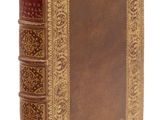 un vieux livre à la couverture brune et à la bordure dorée