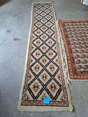 two rugs on the floor in a room with a blue tag on the floor