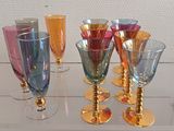 de nombreux verres à vin de différentes couleurs posés sur une table en verre