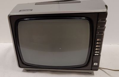 un petit téléviseur posé sur une table blanche