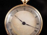 an old gold pocket watch with roman numerals on the face