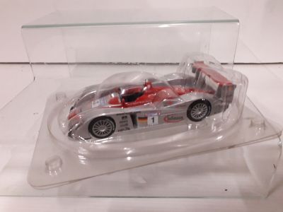 a toy car in a clear display case on a white surface
