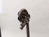 a small metal object with a flower on top of it