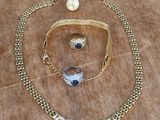 a close up of a necklace and bracelet on a wooden surface
