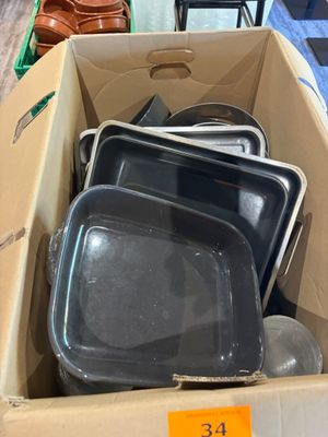 une boîte en carton remplie d'un assortiment de casseroles et de poêles