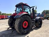 a red tractor that is parked in a parking lot