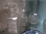 de nombreux vases en verre posés sur une étagère dans une pièce