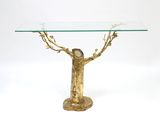 a glass table with a gold tree on it
