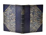an old book with a blue cover with gold designs on it