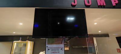 a television mounted above a glass display case in a store