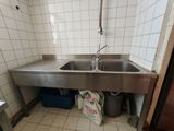 un évier en acier inoxydable dans le coin d'une salle de bains