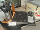 a stove top with a bunch of utensils on top of it
